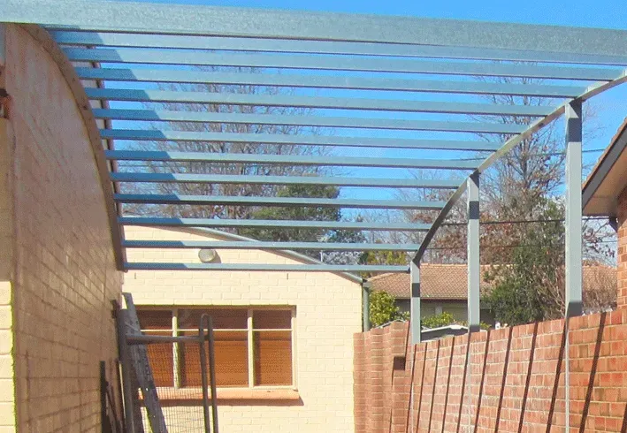 A metal structure is being built on the side of a house