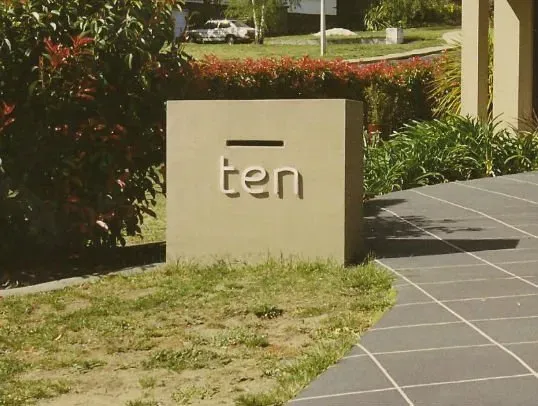 A stone block with the word ten in metal on it