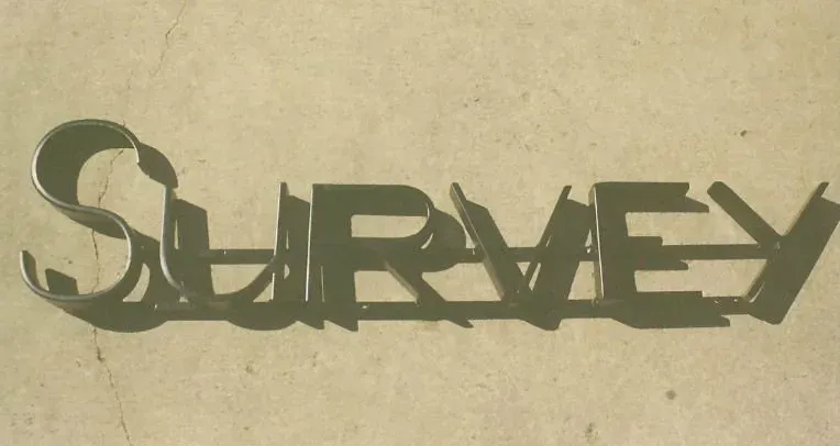 The word survey is cut out in metal