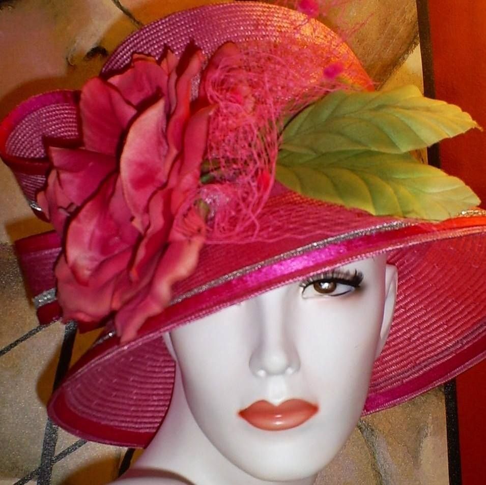 Mannequin head wearing a pink hat with a large pink flower and green leaves.