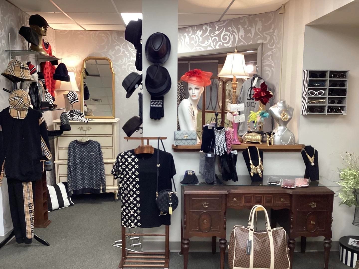 Clothing store interior: mannequins, hats, clothes, mirror, display table, various accessories in shop.