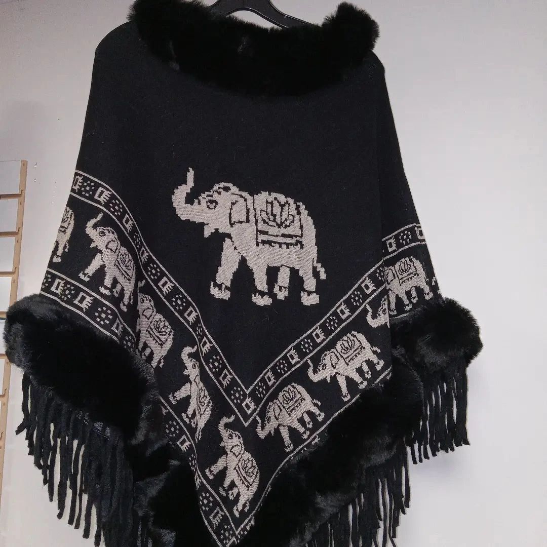 Black poncho with elephant pattern, faux fur trim, and fringe.