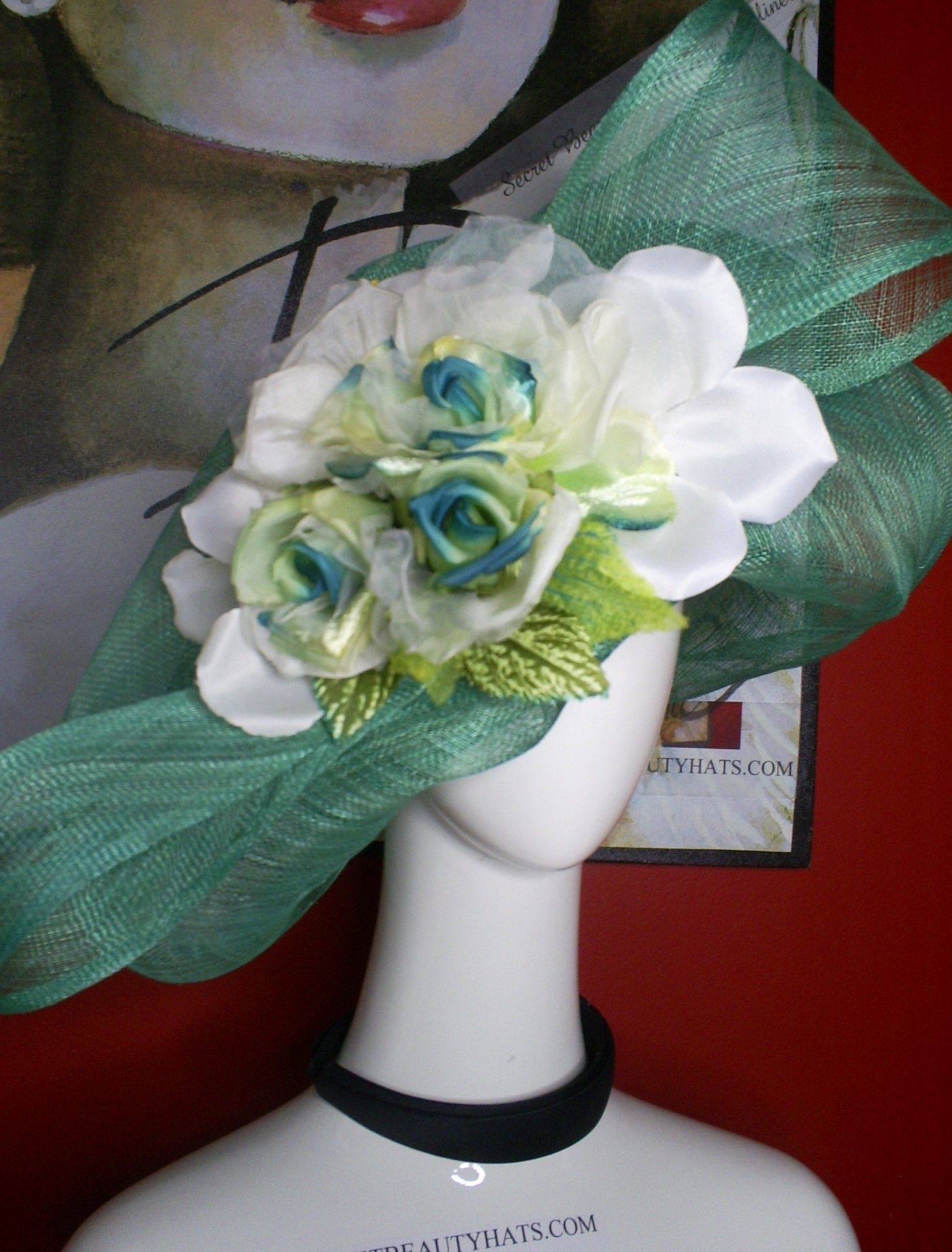 Mannequin wearing a green hat with white and teal flowers.