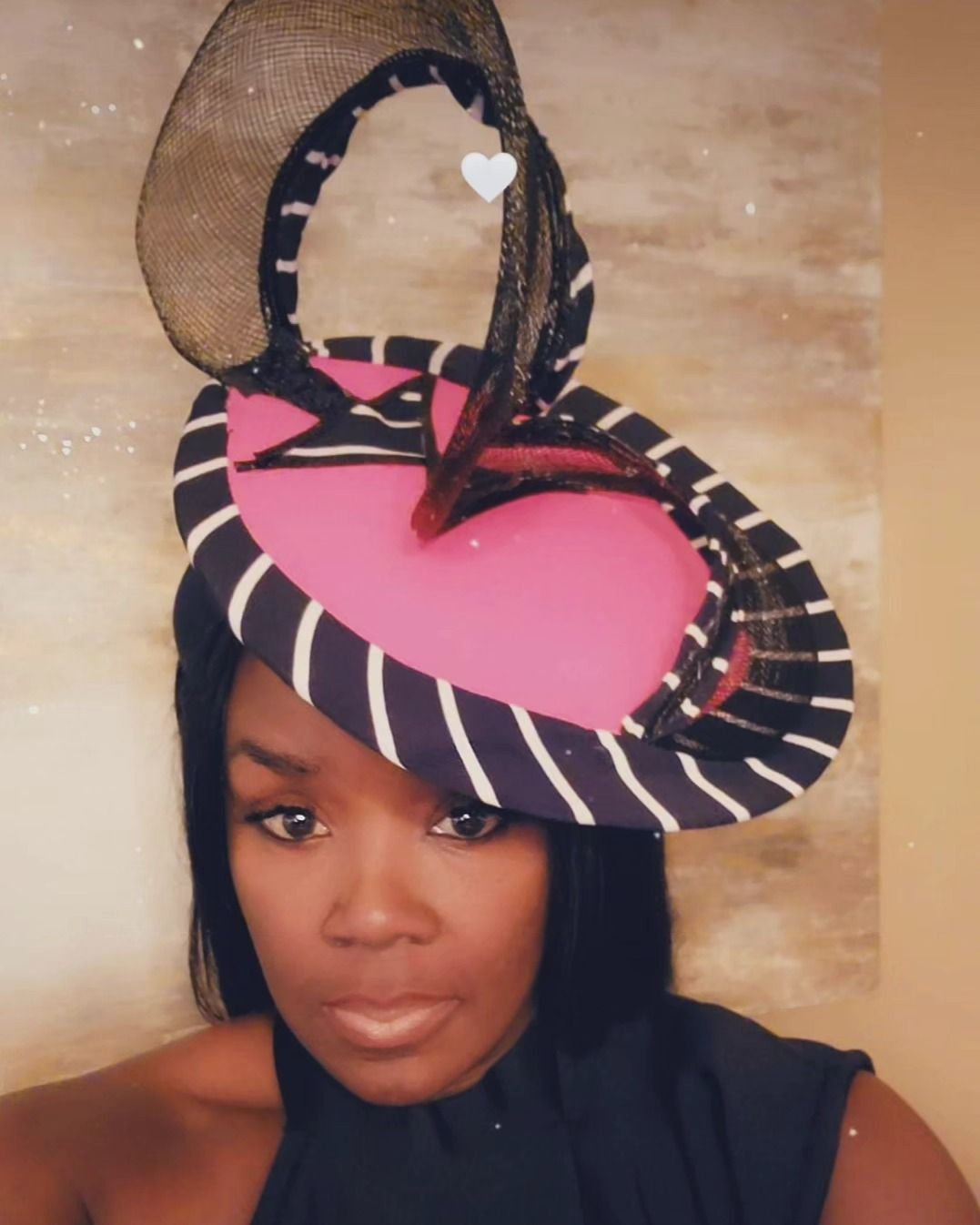 Woman wearing a pink and navy striped hat.