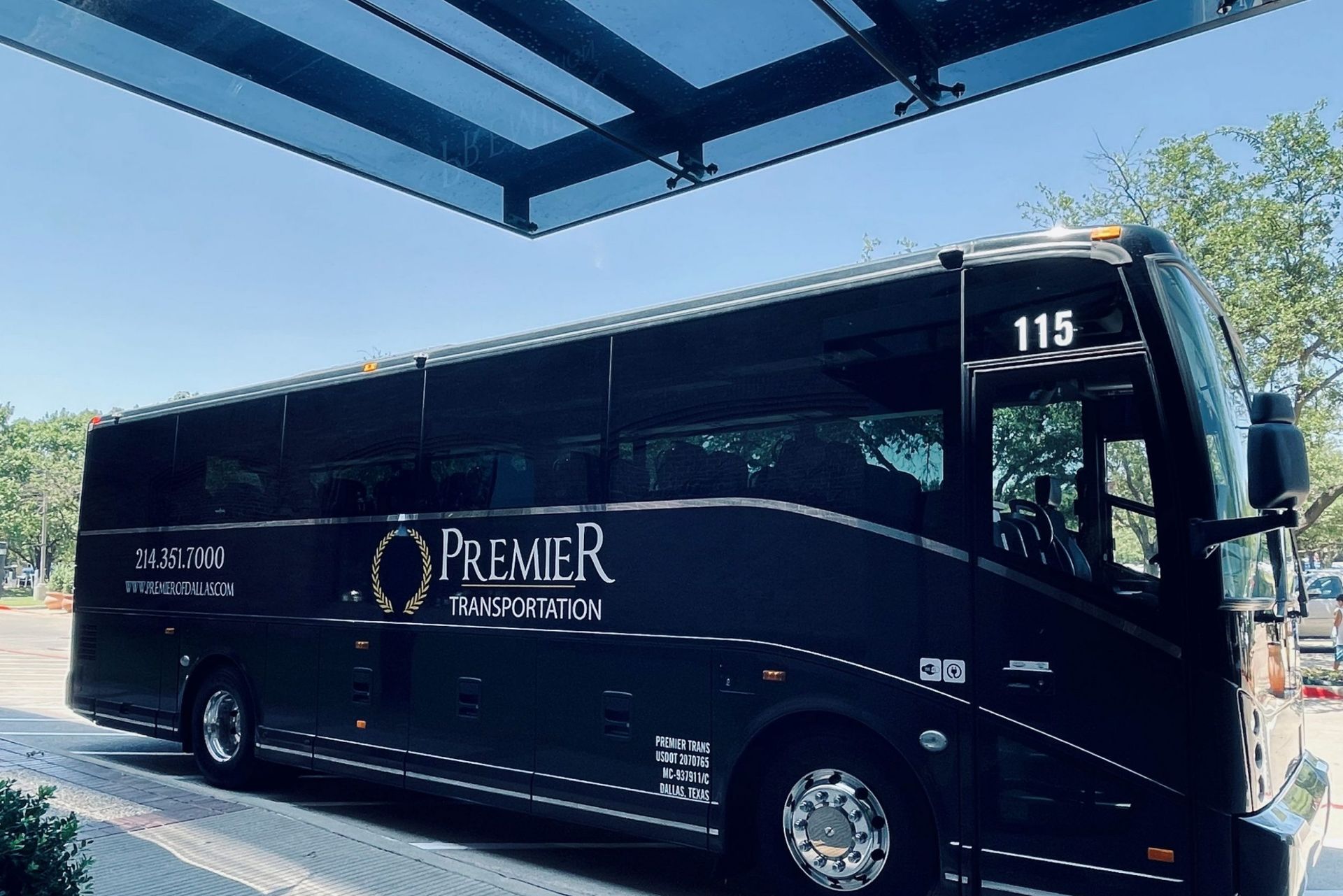 premier's black bus with the number 115 on the side