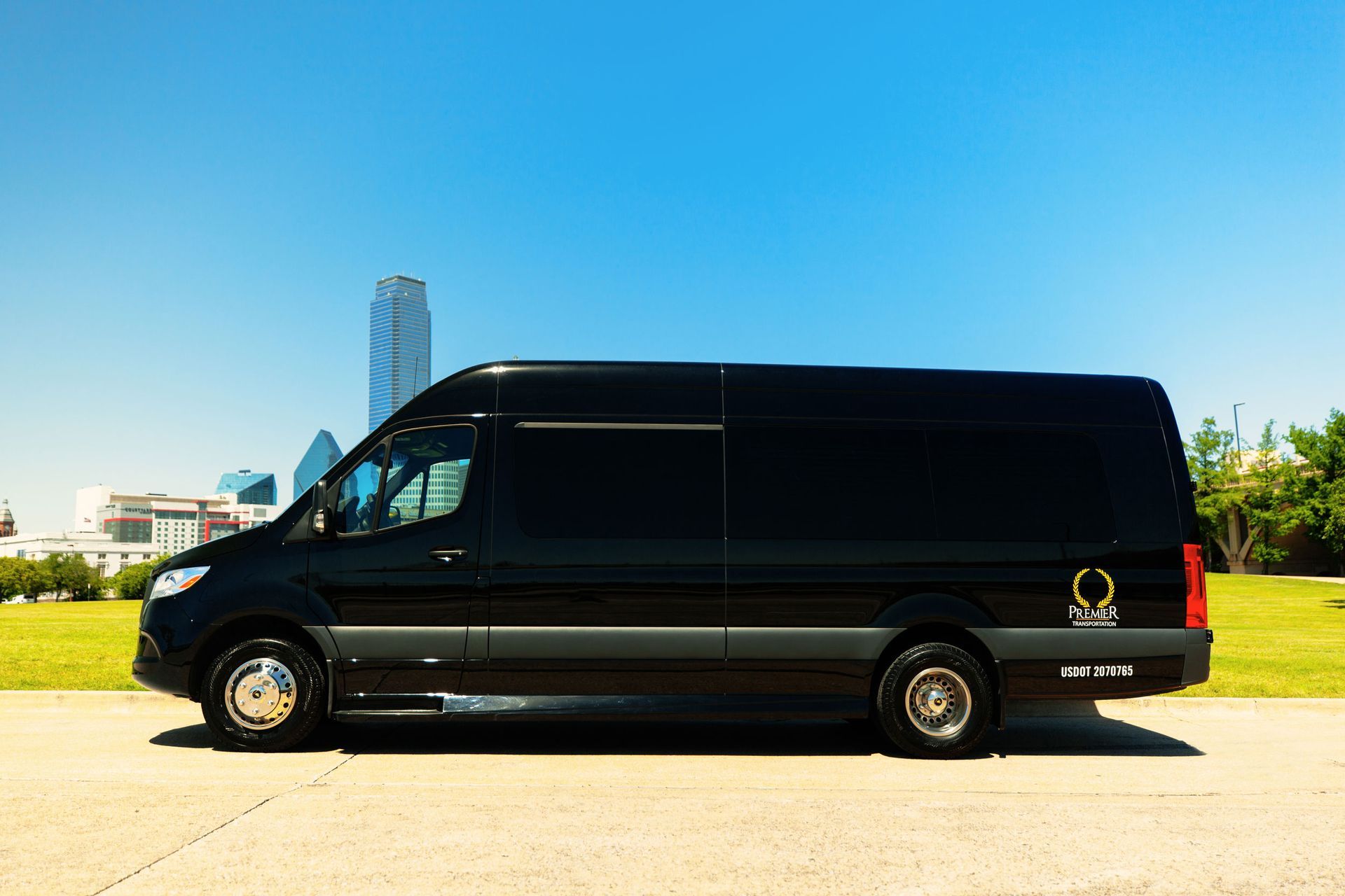 premier's black van is parked on the side of the road in front of a city .