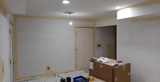 Room interior with white walls, beige trim, and a doorway, under construction.