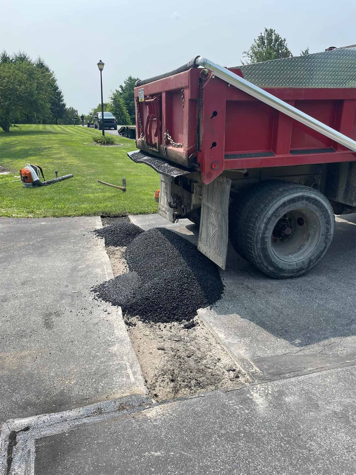 A red dump truck is parked on the side of the road