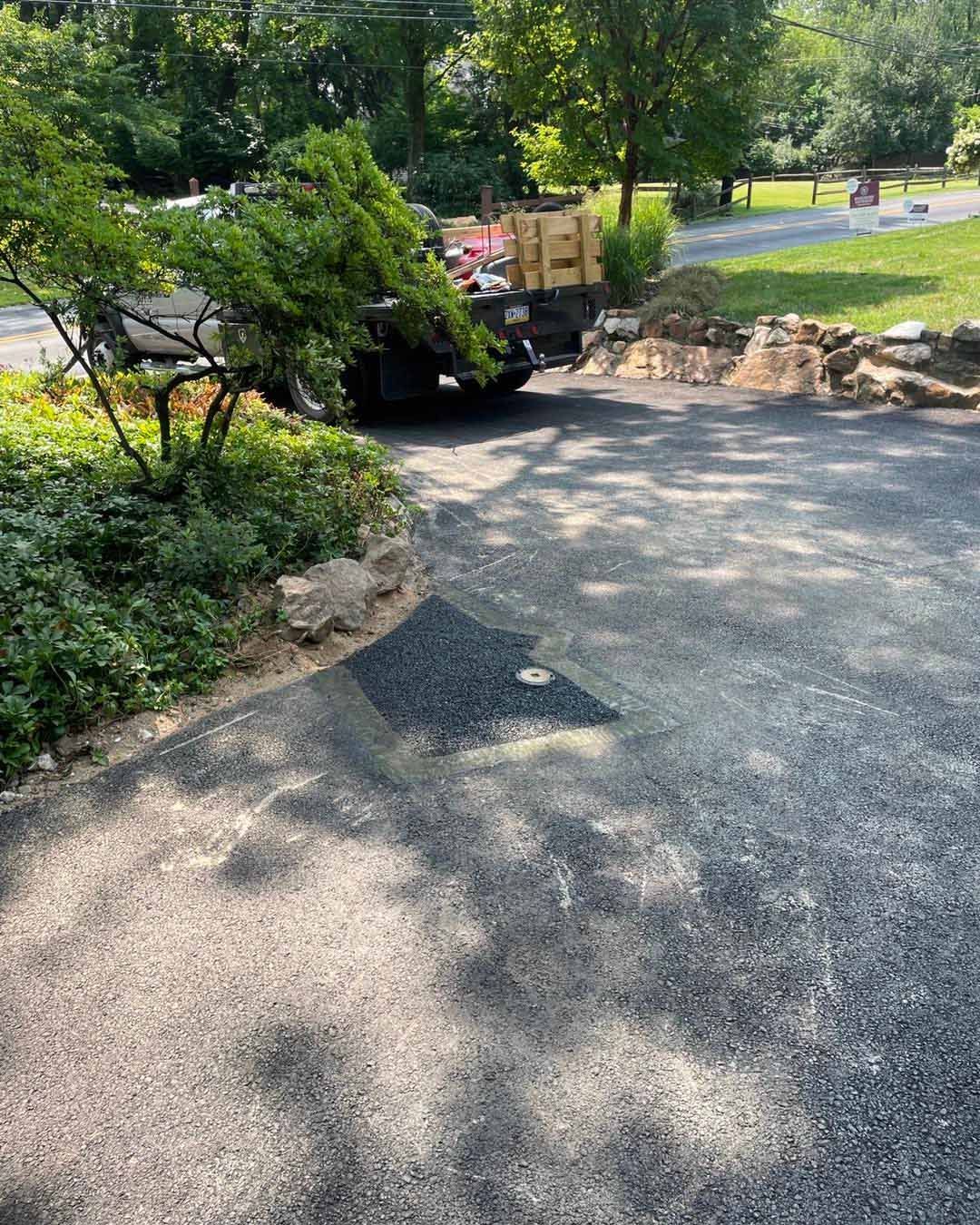 A truck is parked on the side of a road next to a tree