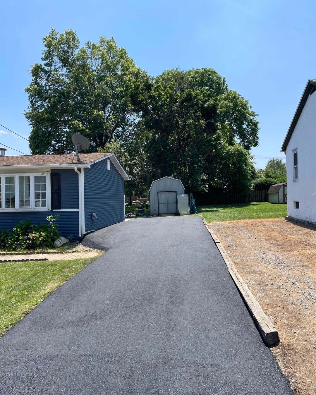 A driveway leading to a house on a sunny day
