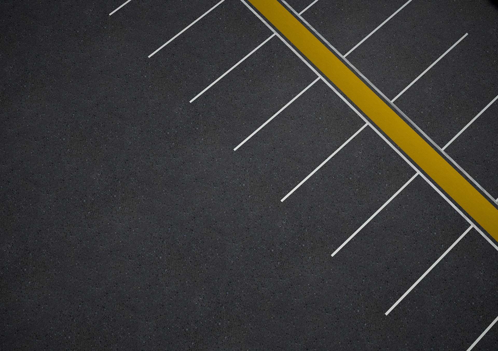 An aerial view of an empty parking lot with a yellow line