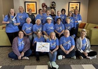 A group of women are posing for a picture for the paducah quilt retreat