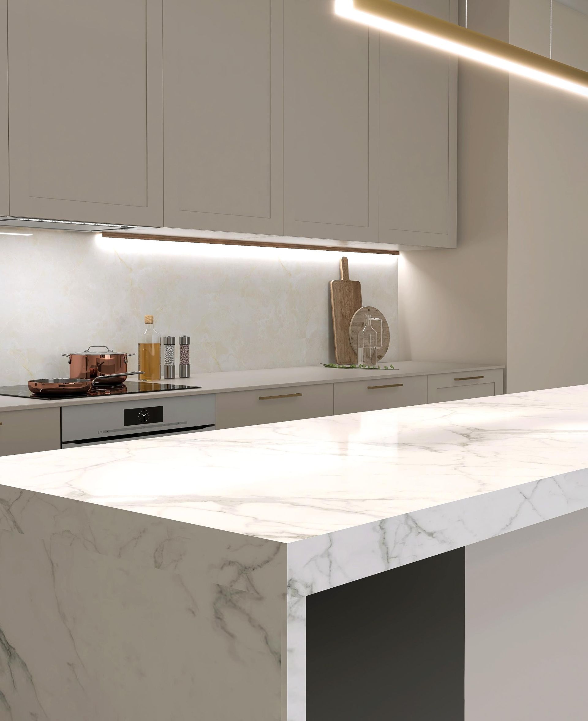 Modern kitchen with white marble countertops and cabinets; wood cutting boards; overhead lighting.