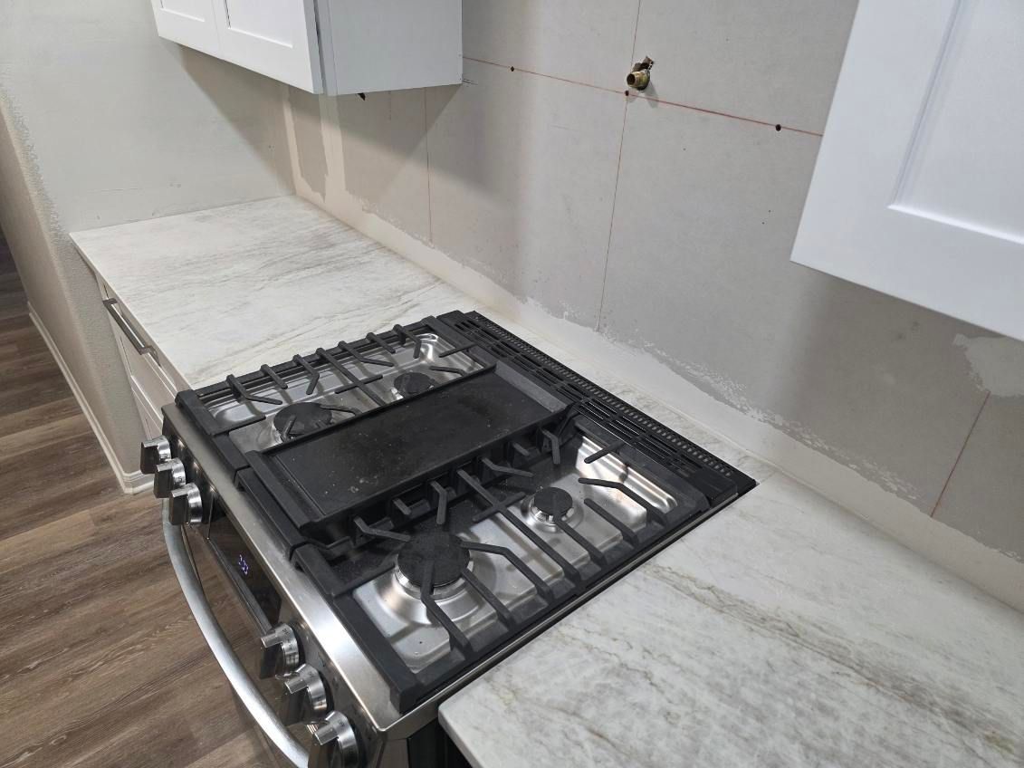 A living room with two couches, a fireplace, and a ceiling fan.