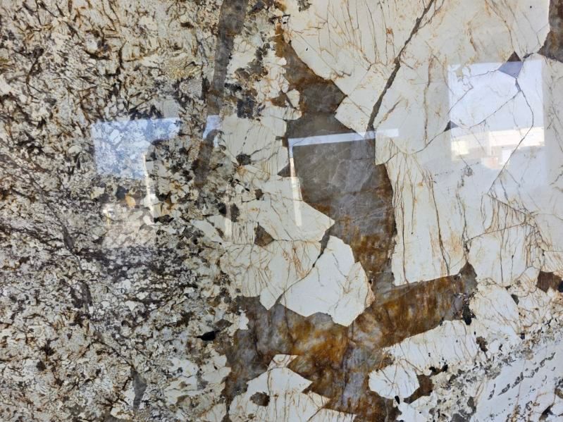 Close-up of a granite countertop with light beige, brown, and dark gray mottled patterns.