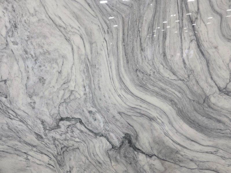 White and gray marble with flowing, wavy veining patterns.