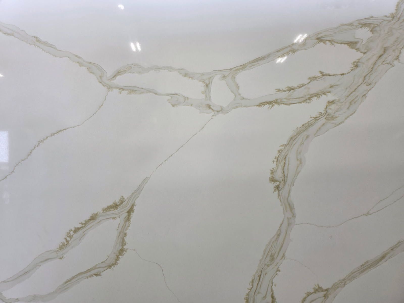 White surface with gold veining, resembling marble or stone.