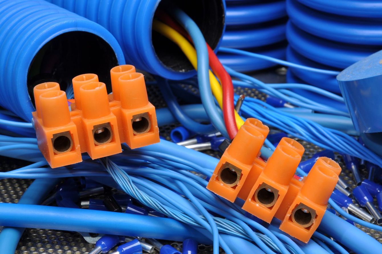 Connettori terminali arancioni su cavi blu in un sistema di gestione dei cavi