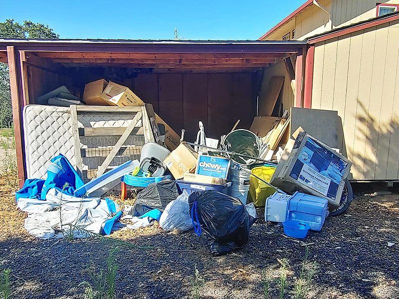 mattress, plastics, woods, and other junks outside a shed