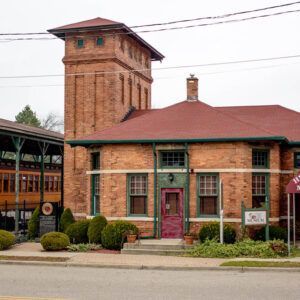A brick building with a red roof and a pink door