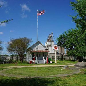 An american flag is flying in front of a gas station.