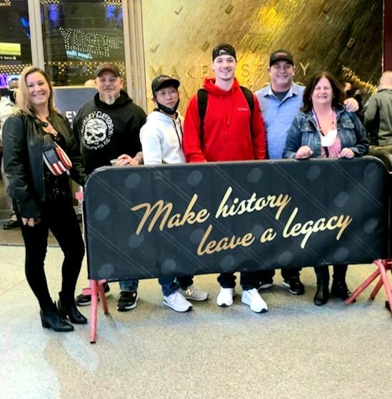 A group of people standing around a sign that says make history leave a legacy