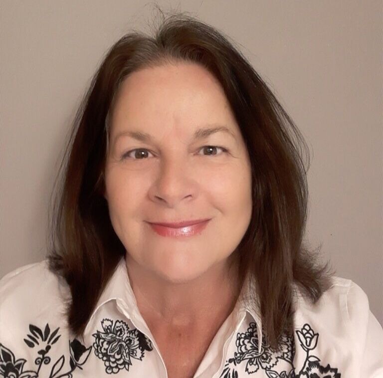 A woman wearing a white shirt with black flowers on it