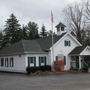 A small white house with a flag in front of it