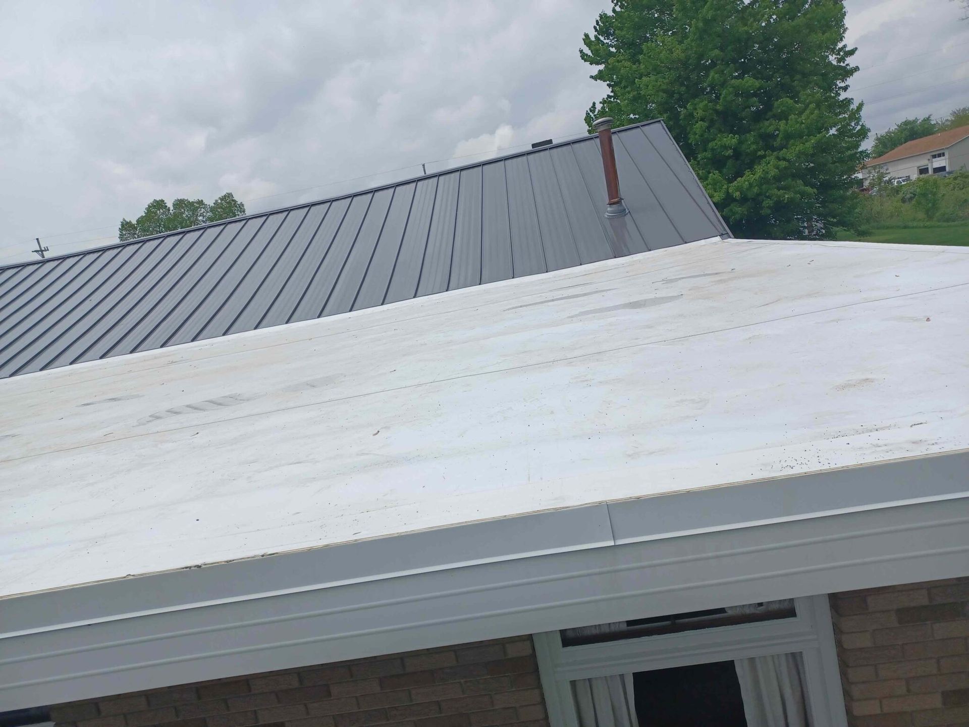 A house with a white roof and a black roof.