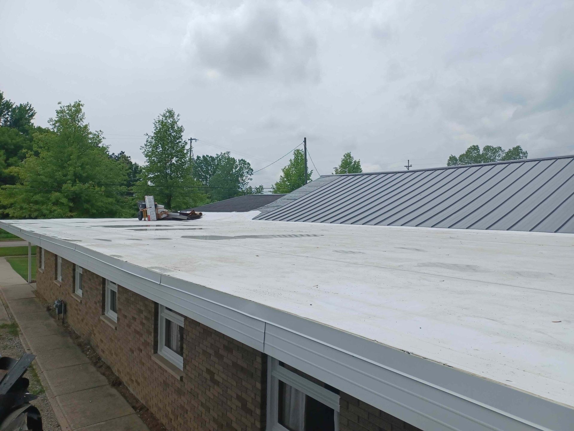 A white roof is being installed on top of a brick building.