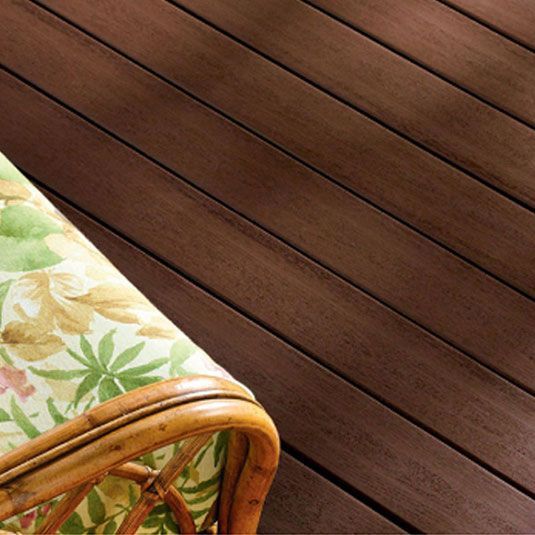 A wicker chair is sitting on a wooden deck