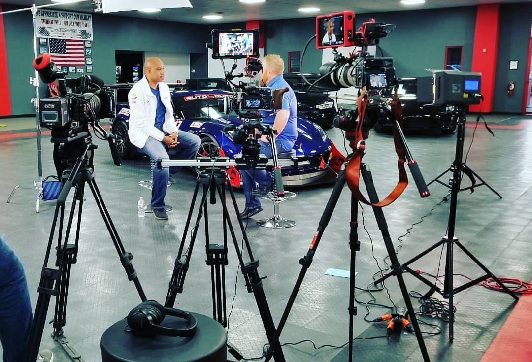A man is sitting in front of a camera in a room.