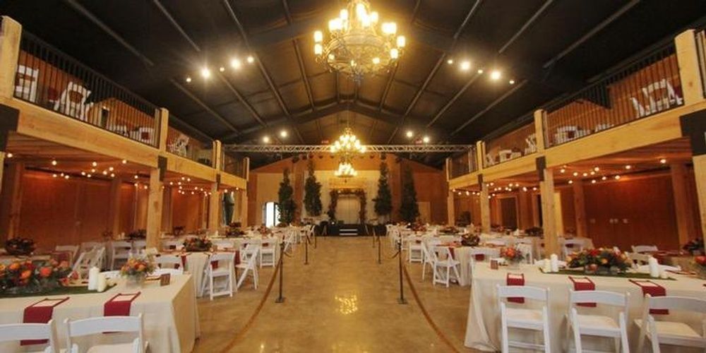 A large room with tables and chairs set up for a wedding reception