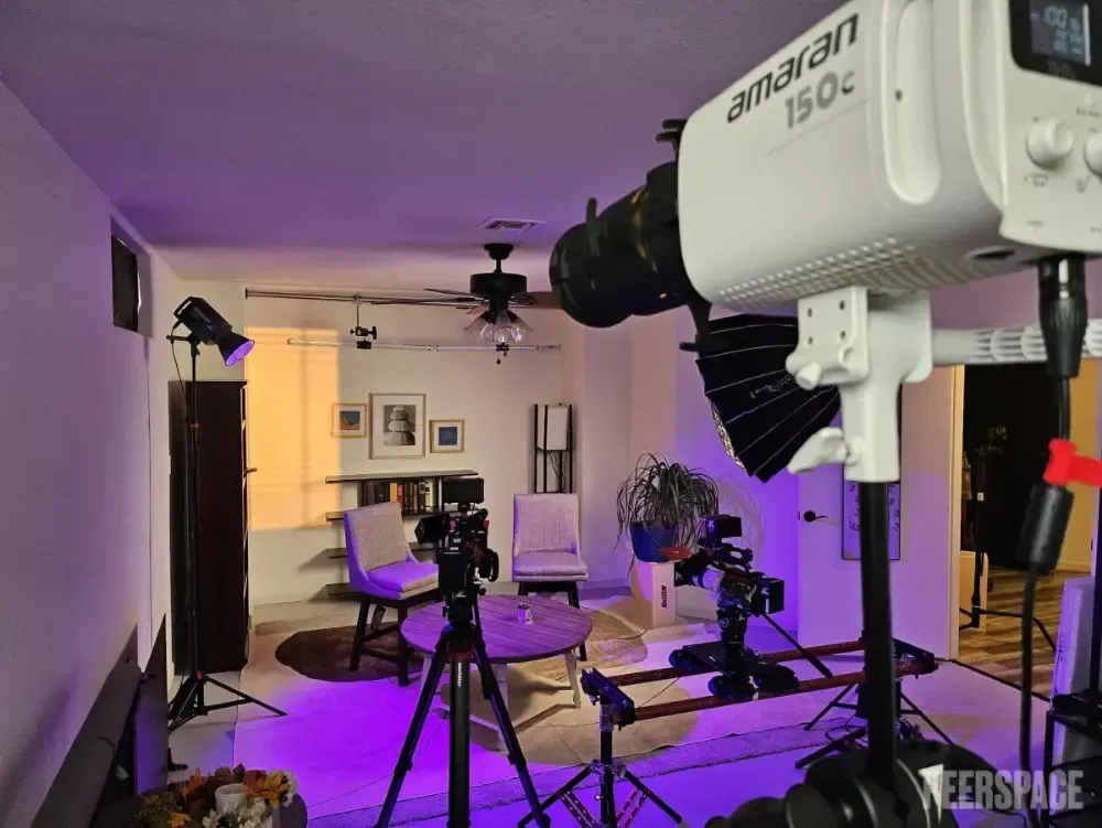 A camera is sitting on a tripod in a living room.