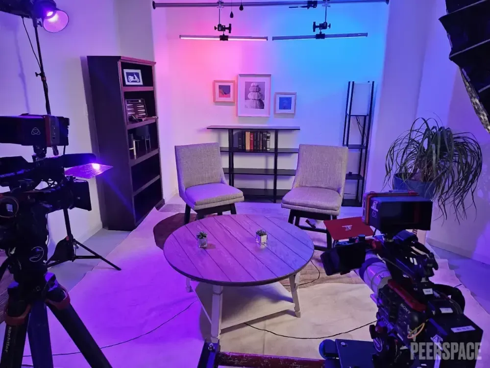 A camera is sitting in a living room with a table and chairs.