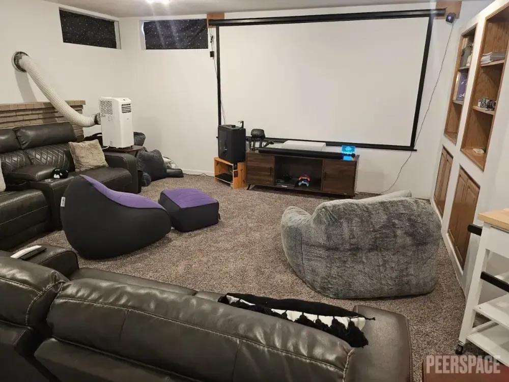 A living room filled with furniture and a projector screen.