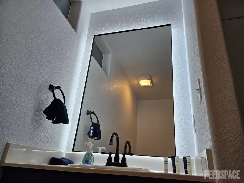 A bathroom vanity with a mirror and a sink