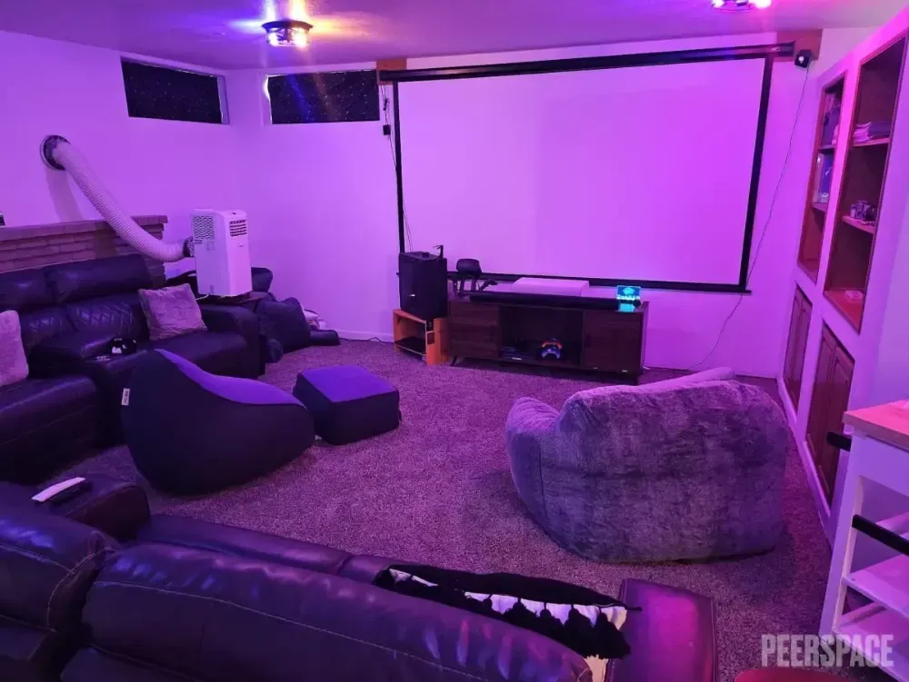 A living room filled with furniture and a projector screen.
