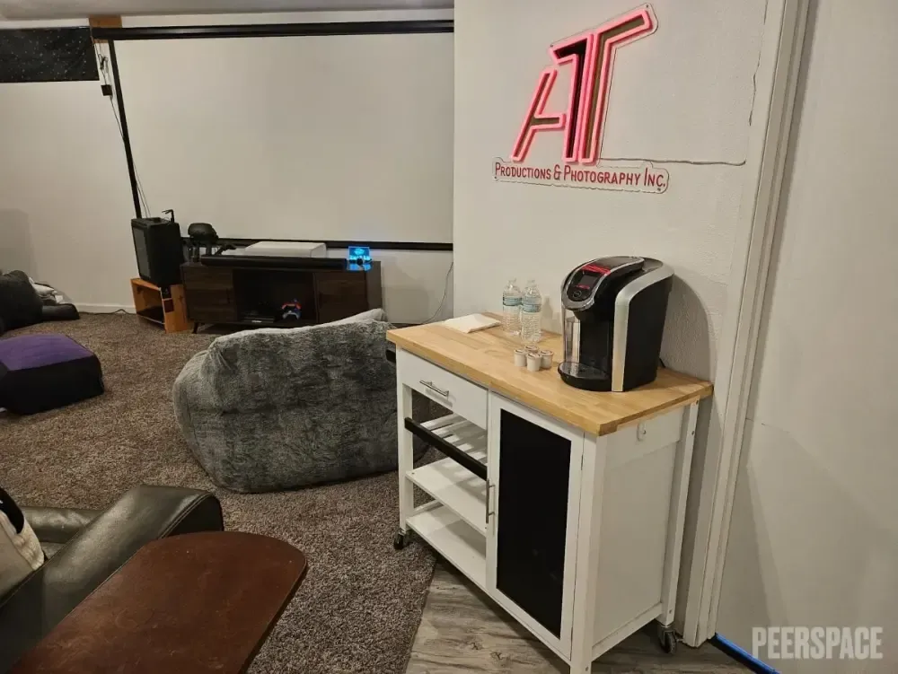 A living room with a coffee maker on a wooden table.
