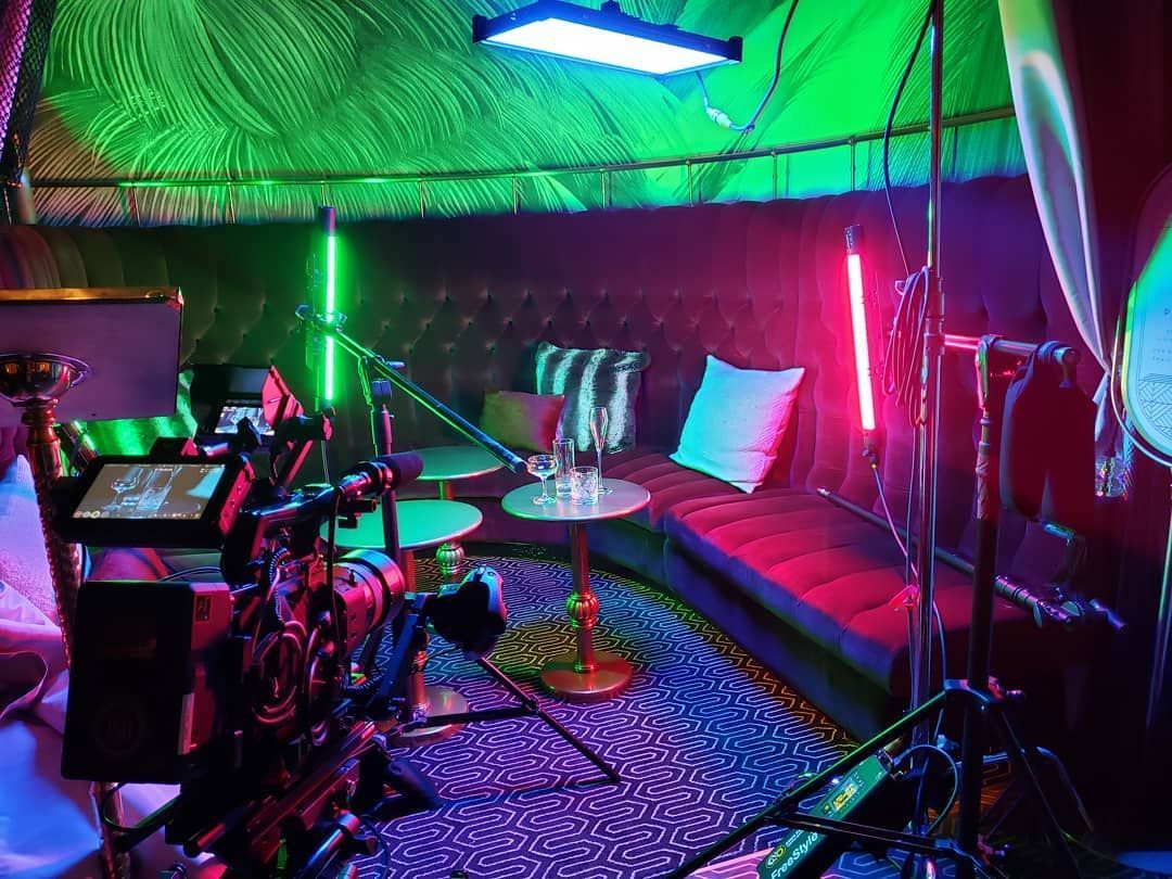 A room with a couch and a table with a lot of lights on it.