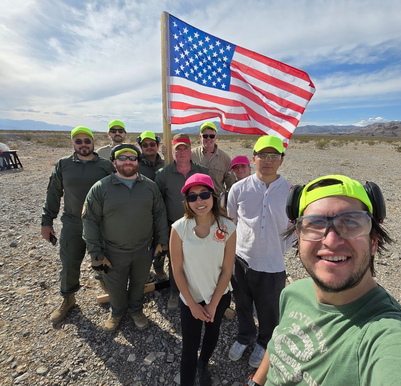 A group of people wearing yellow hats are posing for a picture