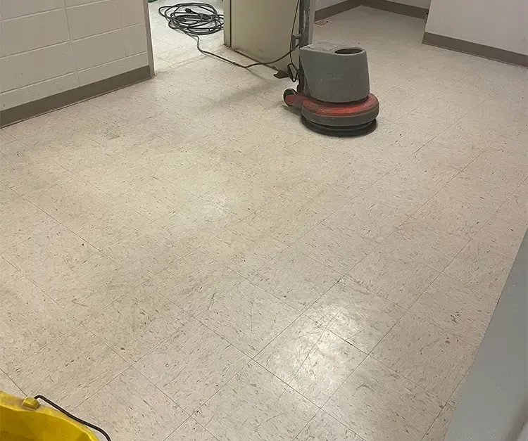 A vacuum cleaner is sitting on a tiled floor in a room.