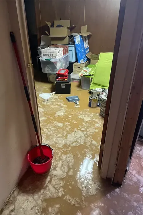 A room with a mop and bucket on the floor.
