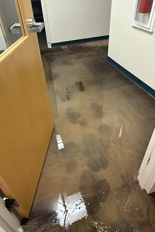 A hallway with a flooded floor and a door.