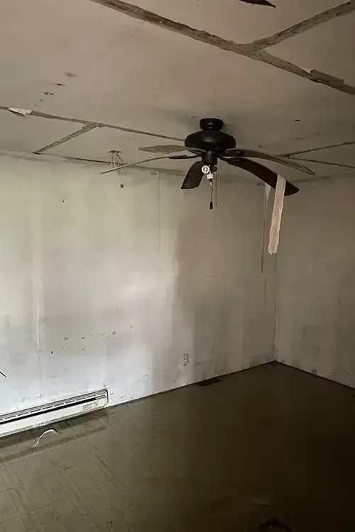 There is a ceiling fan in the corner of the room.