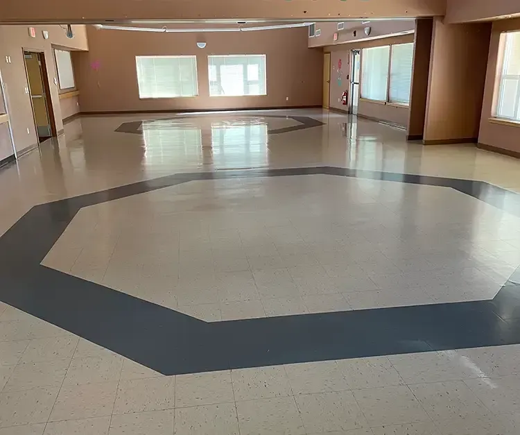 A large empty room with a circular pattern on the floor.