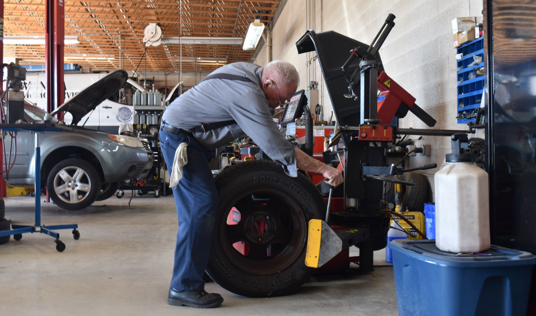 Precision Tire employee working at North Phoenix tire shop, replacing an old tire with a new one