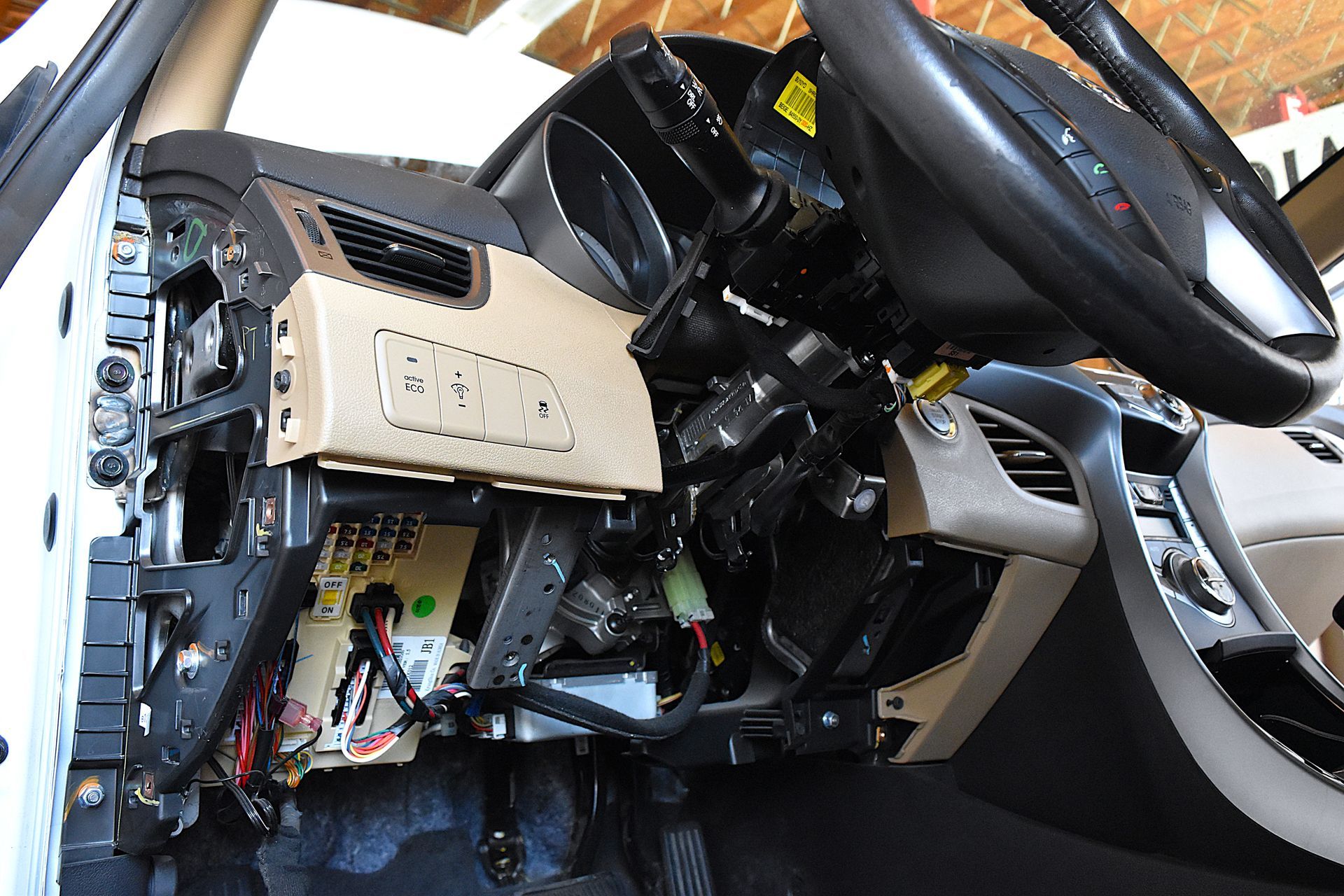 Vehicle interior showing exposed steering column and components during diagnostic service.