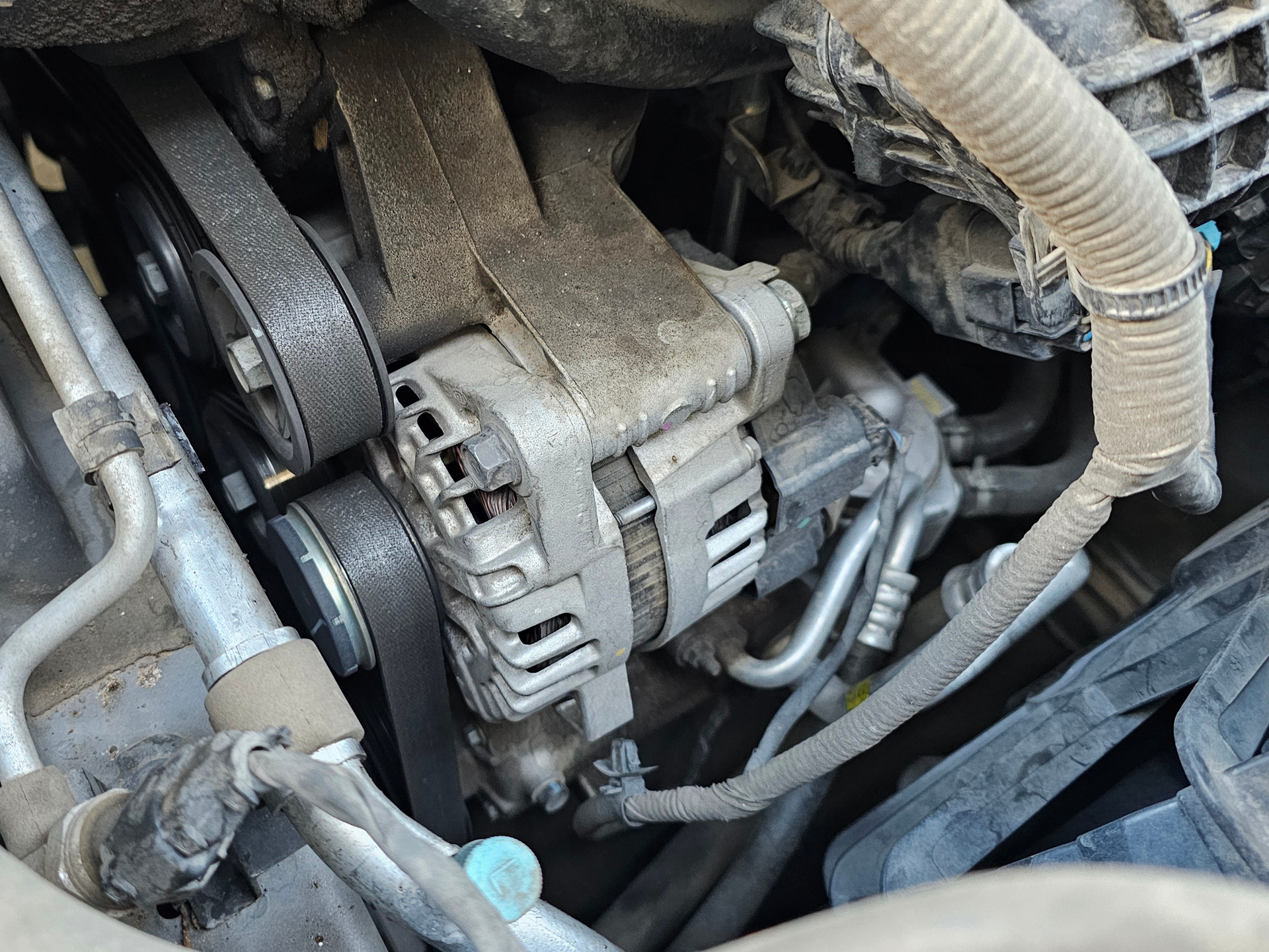 Car alternator close-up showing electrical component that charges battery and helps powers vehicle