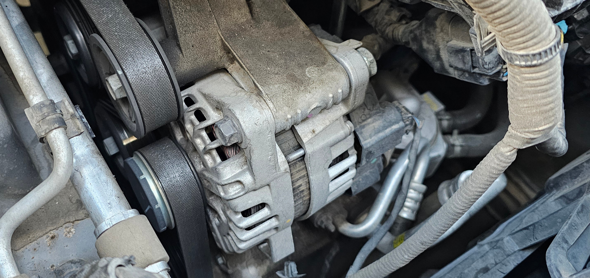 Car alternator close-up showing electrical component that charges battery and helps powers vehicle